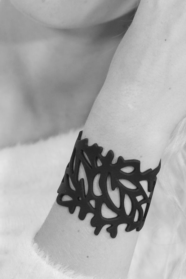 en rupture, zoom, vue gros plan, bracelet corail, couleur noir. Vue taille réelle, porté sur poignet par mannequin Dorine Gaudin. Bijoux fantaisies en silicone, ladygum, marque française, créateurs, designers. Style nature, manchette femme, ajouré, algues, mer. Léger, souple, longueur réglable, bracelet ajustable, fermoir en T, résistant à l'eau, à la chaleur, à la lumière, minimisant les allergies. Cadeau original.