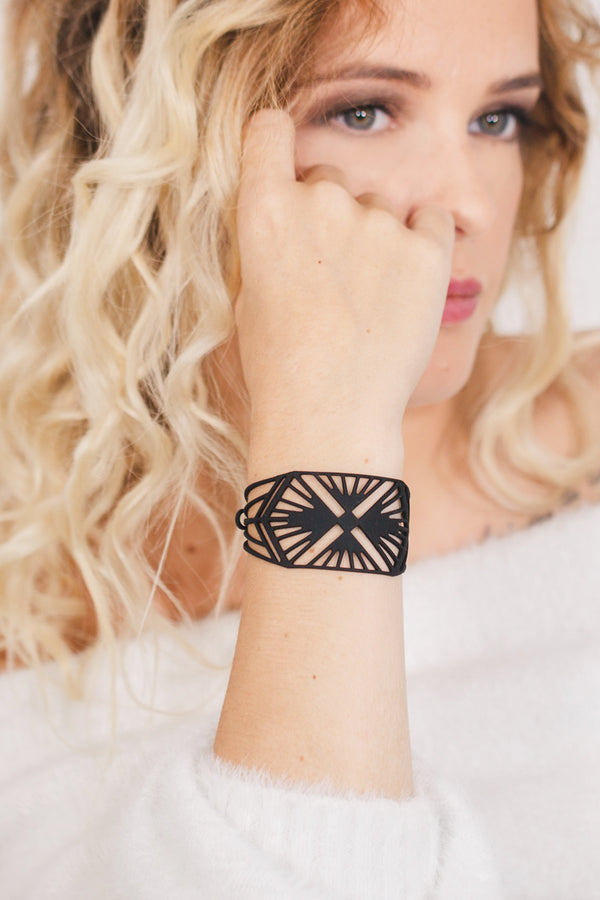 zoom, vue gros plan, bracelet charleston, couleur noir. Vue taille réelle, porté sur poignet par mannequin Dorine Gaudin. Bijoux fantaisies en silicone, ladygum, marque française, créateurs, designers. Style manchette femme, montre, art déco, vintage, rétro, graphique, géométrique. Léger, souple, longueur réglable, bracelet ajustable, fermoir en T, résistant à l'eau, à la chaleur, à la lumière, minimisant les allergies. Cadeau original.