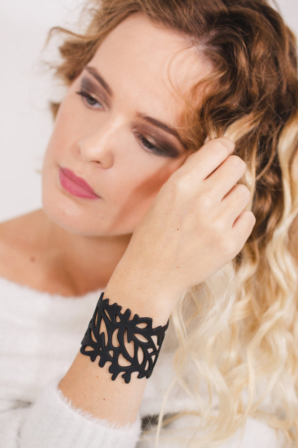 zoom, vue gros plan, bracelet corail, couleur noir. Vue taille réelle, porté sur poignet par mannequin Dorine Gaudin. Bijoux fantaisies en silicone, ladygum, marque française, créateurs, designers. Style nature, manchette femme, ajouré, algues, mer. Léger, souple, longueur réglable, bracelet ajustable, fermoir en T, résistant à l'eau, à la chaleur, à la lumière, minimisant les allergies. Cadeau original.