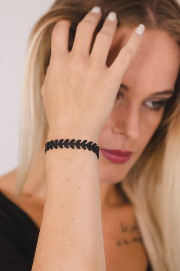zoom, vue gros plan, bracelet épi de blé, couleur noir. Vue taille réelle, porté sur poignet par mannequin Dorine Gaudin. Bijoux fantaisies en silicone, ladygum, marque française, créateurs, designers. Style nature, manchette femme, blé, champêtre, flèche, indien. Léger, souple, longueur réglable, bracelet ajustable, fermoir en T, résistant à l'eau, à la chaleur, à la lumière, minimisant les allergies. Cadeau original.