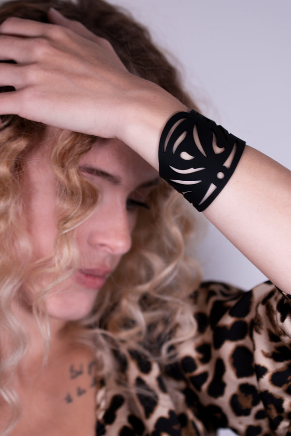 vue gros plan, détails, bracelet maori, couleur noir, mixte, silicone, porté par mannequin, dorine gaudin. Style manchette, polynésien, tribal, ethnique, été, jungle, aztèque, tribu. Bijoux fantaisies, bracelets fantaisies en silicone, ladygum, marque française, créateurs, designers. Longueur réglable, fermoir en T, bracelet ajustable, résistant à l'eau, à la chaleur, à la lumière, minimisant les allergies.