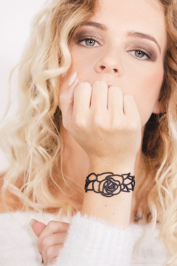 zoom, vue gros plan, bracelet rose, couleur noir. Vue taille réelle, porté sur poignet par mannequin Dorine Gaudin. Bijoux fantaisies en silicone, ladygum, marque française, créateurs, designers. Style nature, manchette femme, fleur, amour, romantique, feuille. Léger, souple, longueur réglable, bracelet ajustable, fermoir en T, résistant à l'eau, à la chaleur, à la lumière, minimisant les allergies. Cadeau original.