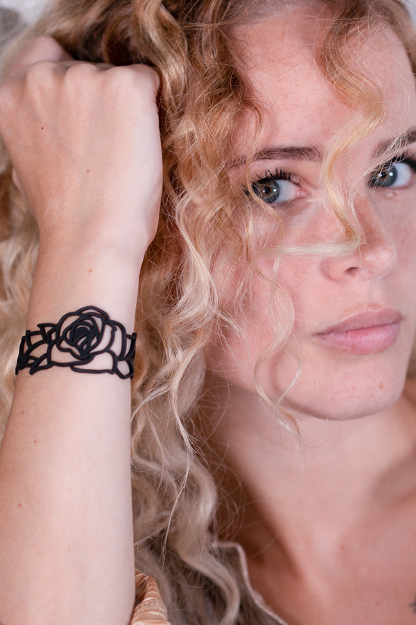 vue taille réelle, bracelet rose, noir, silicone, porté par mannequin, dorine gaudin. Ladygum, bijoux fantaisies, bracelets fantaisies, marque française, créateurs, designers. Style fleur, floral, nature, romantique, rose, fémini. Souple, léger, résistant à l'eau, à la chaleur, à la lumière, minimisant les allergies. Longueur réglable, bracelet ajustable, fermoir en T.