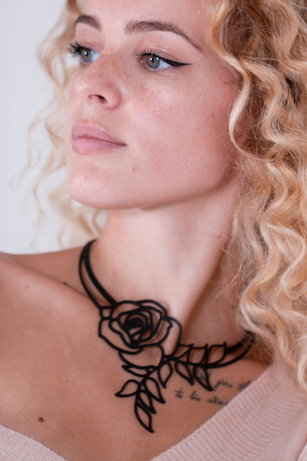 vue collier rose, taille réelle, porté par mannequin, dorine gaudin. Silicone, noir, ladygum, marque française, bijoux fantaisies, créateurs, designers. Style fleur, floral, romantique, amour. Minimisant les allergies, résistant à l'eau, à la chaleur, léger, souple, longueur réglable, ajustable, fermoir en T. Modèle Rose, long, plongeant.