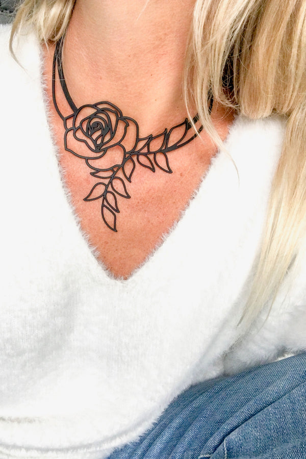 vue collier rose, taille réelle, porté par mannequin, morgane. Silicone, noir, ladygum, marque française, bijoux fantaisies, créateurs, designers. Style fleur, floral, romantique, amour. Minimisant les allergies, résistant à l'eau, à la chaleur, léger, souple, longueur réglable, ajustable, fermoir en T. Modèle Rose, long, plongeant.