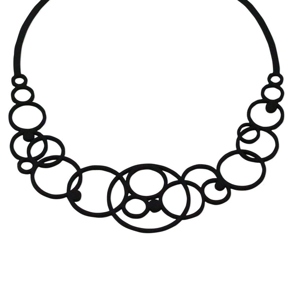 vue gros plan, détails, taille réelle, collier disco. Ladygum, bijoux fantaisies, marque française, créateurs, designers. Silicone, disponible en noir. Style rond, cercle, bulle, années 70, seventies, hippie. Minimisant les allergies, léger, souple, longueur réglable, bijou ajustable, résistant à l'eau et à la chaleur. Modèle disco.
