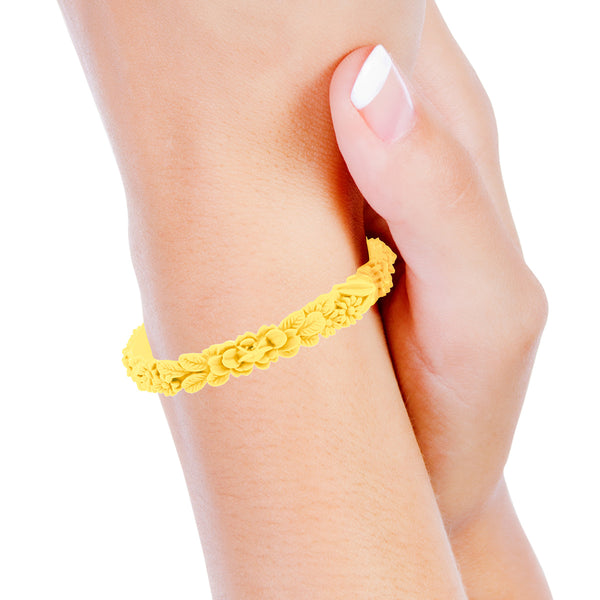 vue portée au poignet par mannequin, zoom, vue gros plan, bracelet boho les fleurettes, couleur citron. Bijoux fantaisies en silicone, ladygum, marque française. Bracelet aux fleurs en relief, non ajustable, taille unique, facile à enfiler au poignet. Cadeau original.