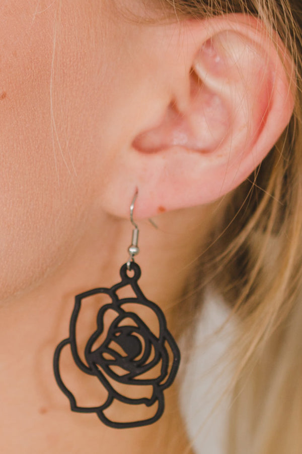 zoom, vue gros plan, paire de boucles d'oreilles rose, couleur noir. Portées par mannequin Dorine Gaudin. Bijoux fantaisies en silicone, marque française, créateurs, designers. Style fleur, floral, nature, amour, pétale. Attache dormeuse en acier inoxydable. Minimisant les allergies, résistant à l'eau/à la chaleur/à la lumière, souple, léger. Cadeau original.