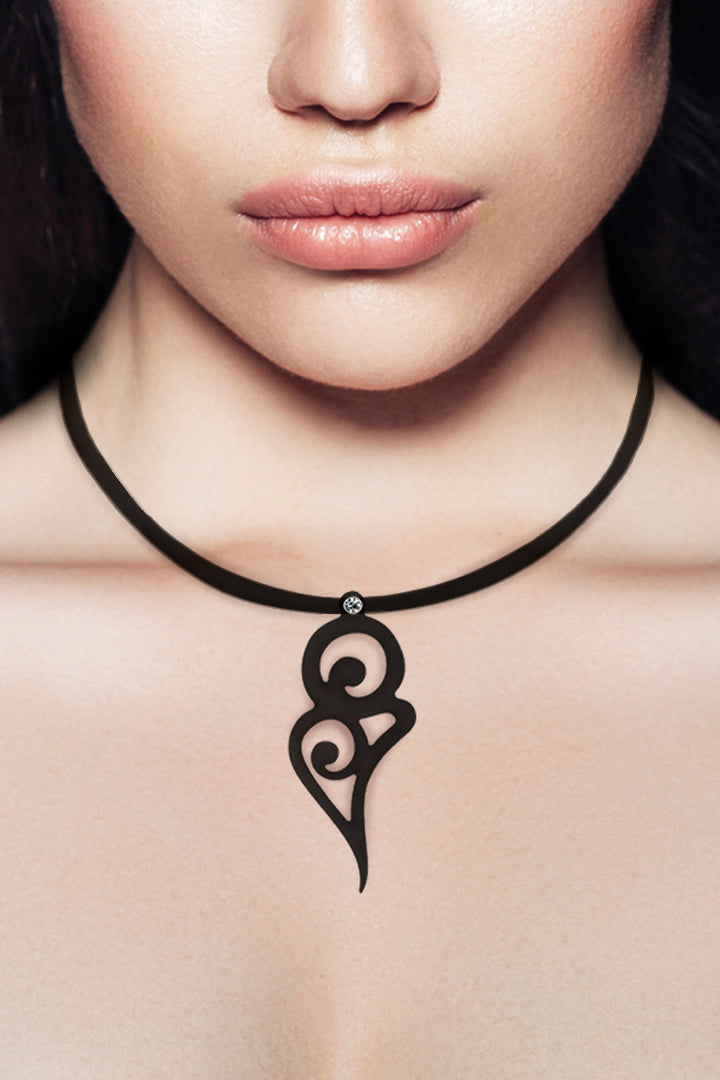 zoom, vue gros plan, collier pendentif courbe, couleur noir. Taille réelle. Bijoux fantaisies en silicone, ladygum, marque française, créateurs, designers. Collier simplissimo avec strass swarovski, cristal, amovible, riveté, et pendentif boucle courbe. Style simple, minimaliste, interchangeable avec d'autres pendentifs, graphique, rond, cercle, tourbillon. Léger, souple, longueur réglable, ajustable, fermoir en T, résistant à l'eau/à la chaleur/à la lumière. Cadeau original.