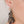 zoom, gros plan, vue boucles d'oreilles rose japonaise modèle long, couleur noir. Portées par mannequin dorine gaudin. Attache dormeuse en acier inoxydable. Silicone, marque française, ladygum, bijoux fantaisies en silicone. Style fleur, floral, nature, romantique, pendantes, longues. Résistante à l'eau/à la chaleur/à la lumière. Souple, léger, original.