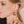 zoom, vue gros plan, paire de boucles d'oreilles love 2 love, couleur noir. Portées par mannequin Dorine Gaudin. Bijoux fantaisies en silicone, marque française, créateurs, designers. Style minimaliste, coeur, amour, courte, petite, créole. Attache dormeuse en acier inoxydable. Minimisant les allergies, résistant à l'eau/à la chaleur/à la lumière, souple, léger. Cadeau original.