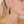 zoom, vue gros plan, paire de boucles d'oreilles emeraude, couleur noir. Portées par mannequin Dorine Gaudin. Bijoux fantaisies en silicone, marque française, créateurs, designers. Style pendante, minimaliste, feuille, longues. Attache dormeuse en acier inoxydable. Minimisant les allergies, résistant à l'eau/à la chaleur/à la lumière, souple, léger. Cadeau original.