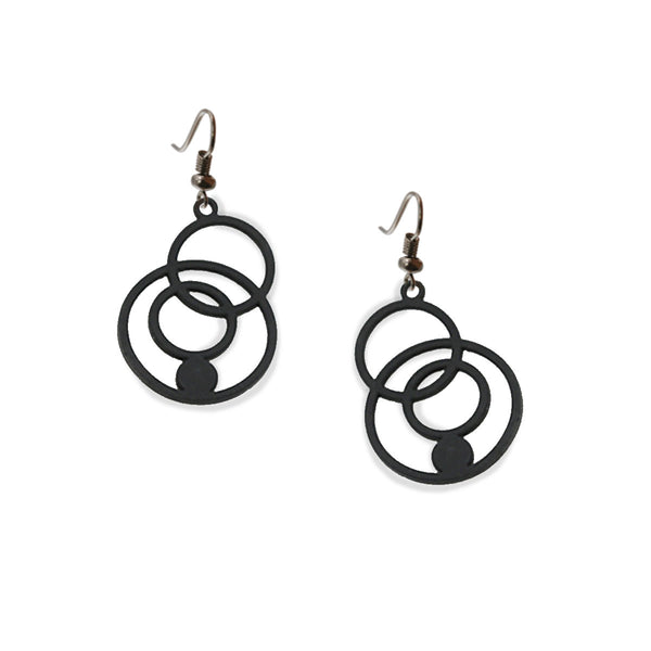 vue à plat, en entier, paire de boucles d'oreilles disco, couleur noir. Bijoux fantaisies en silicone, marque française, créateurs, designers. Style pendante, cercle, rond, vintage, géométrique, sphère, bulles, graphique. Attache dormeuse en acier inoxydable. Minimisant les allergies, résistant à l'eau/à la chaleur/à la lumière, souple, léger. Cadeau original.