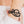 zoom, vue gros plan, bracelet courbe, couleur noir. Vue taille réelle, porté sur poignet par mannequin Dorine Gaudin. Bijoux fantaisies en silicone, ladygum, marque française, créateurs, designers. Style nature, manchette femme, fleur, rond, cercle, tourbillon, abstrait, contemporain. Léger, souple, longueur réglable, bracelet ajustable, fermoir en T, résistant à l'eau, à la chaleur, à la lumière, minimisant les allergies. Cadeau original.