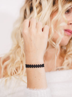 zoom, vue gros plan, bracelet épi de blé, couleur noir. Vue taille réelle, porté sur poignet par mannequin Dorine Gaudin. Bijoux fantaisies en silicone, ladygum, marque française, créateurs, designers. Style nature, manchette femme, blé, champêtre, flèche, indien. Léger, souple, longueur réglable, bracelet ajustable, fermoir en T, résistant à l'eau, à la chaleur, à la lumière, minimisant les allergies. Cadeau original.