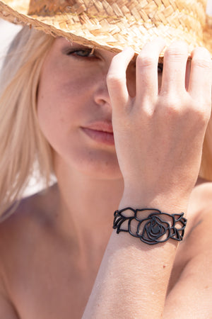 zoom, vue gros plan, bracelet rose, couleur noir. Vue taille réelle, porté sur poignet par mannequin Dorine Gaudin. Bijoux fantaisies en silicone, ladygum, marque française, créateurs, designers. Style nature, manchette femme, fleur, amour, romantique, feuille. Léger, souple, longueur réglable, bracelet ajustable, fermoir en T, résistant à l'eau, à la chaleur, à la lumière, minimisant les allergies. Cadeau original.