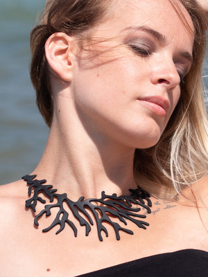 zoom, vue gros plan, collier corail, couleur noir, dispo en rouge/corail. Vue taille réelle, porté par mannequin dorine gaudin. Bijoux fantaisies en silicone, ladygum, marque française, créateurs, designers. Style plastron, algues, mer, plante, feuille, nature. Léger, souple, résistant à l'eau/à la chaleur/à la lumière. Collier ajustable, longueur réglable, fermoir en T. Cadeau original.