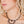 zoom, vue gros plan, collier nymphéa, couleur noir. Vue taille réelle, porté par mannequin dorine gaudin. Bijoux fantaisies en silicone, ladygum, marque française, créateurs, designers. Style fleur, nature, floral, pampilles, zen, yogo, lotus, nénuphar, pétales. Léger, souple, résistant à l'eau/à la chaleur/à la lumière. Collier ajustable, longueur réglable, fermoir en T. Cadeau original.
