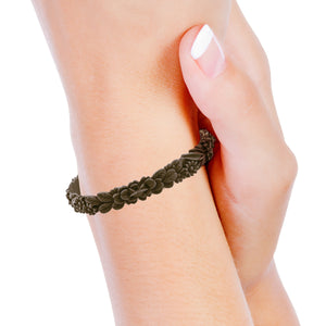 vue portée au poignet par mannequin, zoom, vue gros plan, bracelet boho les fleurettes, couleur chocolat, marron foncé, brun foncé. Laydugm, bijoux fantaisies en silicone, marque frnaçaise. Bracelet non ajustable, taille unique, facile à enfiler au poignet. Bracelets aux fleurs en relief. Cadeau original