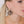 zoom, vue gros plan, paire de boucles d'oreilles charleston, couleur noir. Portées par mannequin Dorine Gaudin. Bijoux fantaisies en silicone, marque française, créateurs, designers. Style éventail, art déco, rétro, géométrique, graphique, moderne, contemporain. Attache dormeuse en acier inoxydable. Minimisant les allergies, résistant à l'eau/à la chaleur/à la lumière, souple, léger. Cadeau original.
