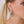 zoom, vue gros plan, boucles d'oreilles Nymphéa, couleur noir, portées sur mannequin Dorine. Attache dormeuse en acier inoxydable. Bijoux fantaisies, marque française, créateurs, designers. Petit modèle, style minimaliste, losange, pampilles, fleurs, géométrique. Silicone, souple, léger, minimisant les allergies, résistant à l'eau/à la chaleur/à la lumière. Idée cadeau original.