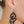 zoom, vue gros plan, paire de boucles d'oreilles courbe, grand modèle, couleur noir. Portées par mannequin Dorine Gaudin. Bijoux fantaisies en silicone, marque française, créateurs, designers. Style fleur, floral, rond, longues, pendantes. Attache dormeuse en acier inoxydable. Minimisant les allergies, résistant à l'eau/à la chaleur/à la lumière, souple, léger. Cadeau original.