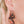 zoom, vue gros plan, paire de boucles d'oreilles courbe, petit modèle, couleur noir. Portées par mannequin Dorine Gaudin. Bijoux fantaisies en silicone, marque française, créateurs, designers. Style fleur, floral, rond, longues, pendantes. Attache dormeuse en acier inoxydable. Minimisant les allergies, résistant à l'eau/à la chaleur/à la lumière, souple, léger. Cadeau original.